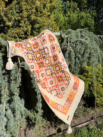 Decorative rug with geometric pattern hanging from a tree